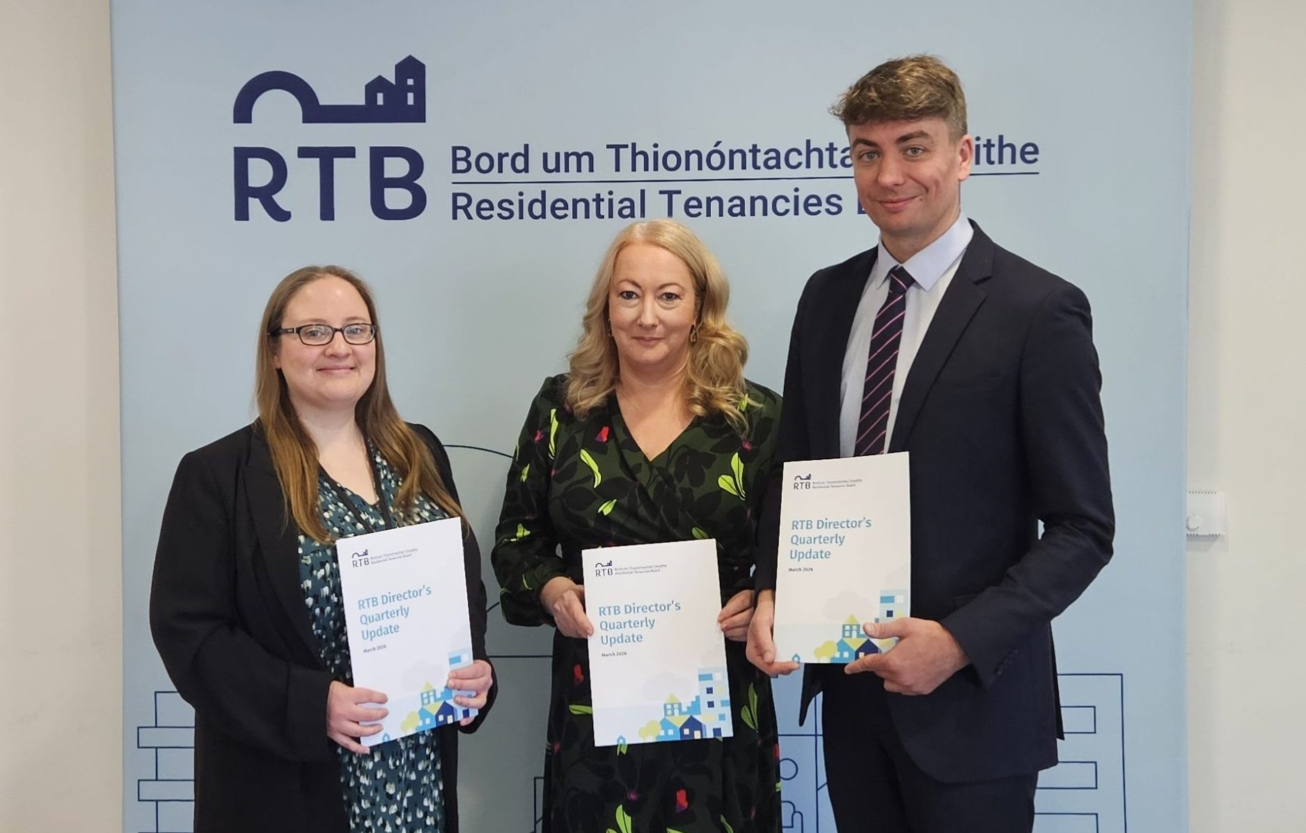 Blue background with two women and a man in front of it